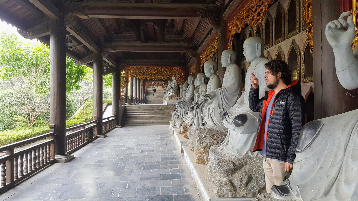Robin au milieu des statues de moines à la pagode Bái Đính