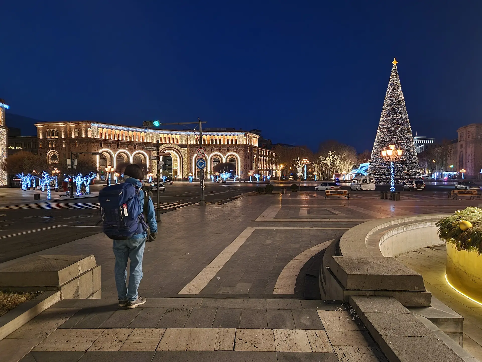 Clara debout sur l'immense place de la République. Le soleil est encore couché, l'éclairage de la place vient des lampadaires et des décorations de Noël.