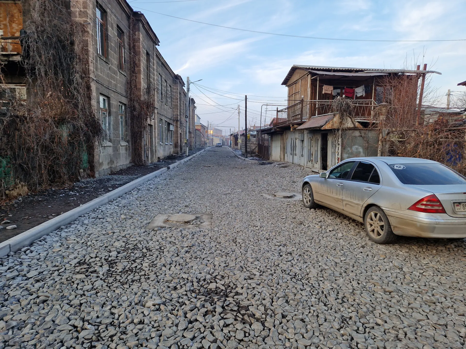 Une ruelle de Gyumri couverte de cailloux, maisons de un ou deux étages.