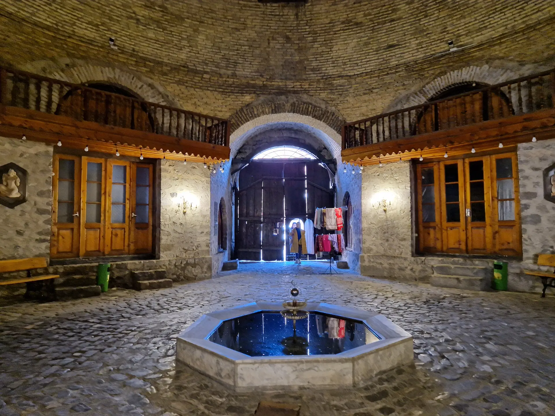 Le 'hall d'entrée' du caravansérail. Une pièce ronde avec une petite fontaine en son milieu et un balcon intérieur.