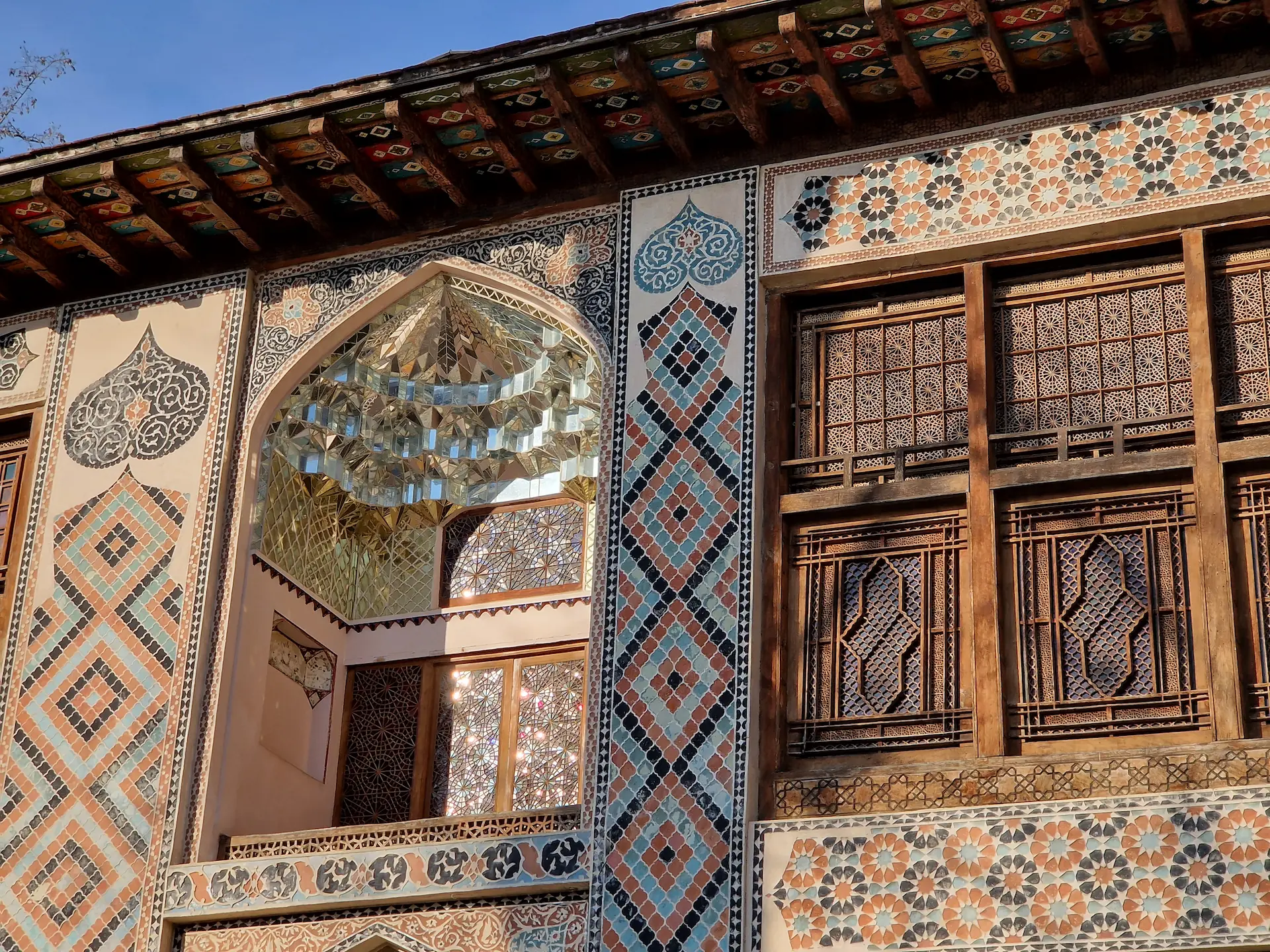 La façade du palais est décoré de tout un tas de formes et couleurs différentes. Une fenêtre est mise en valeur avec un jeu de miroirs.