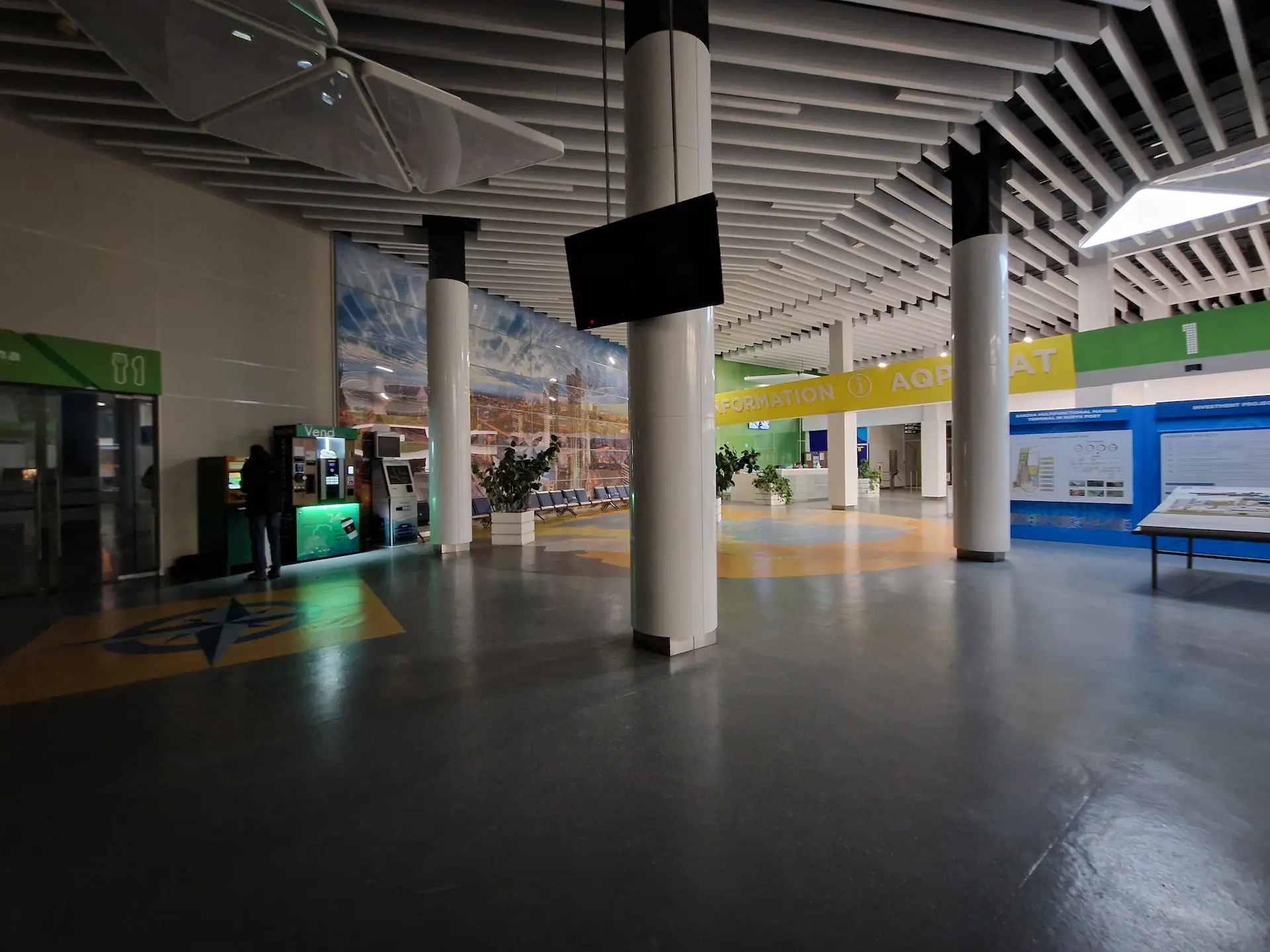 Le centre d'information est un grand hall vide à demi dans la pénombre. On voit des bancomats et machines à café illuminés.
