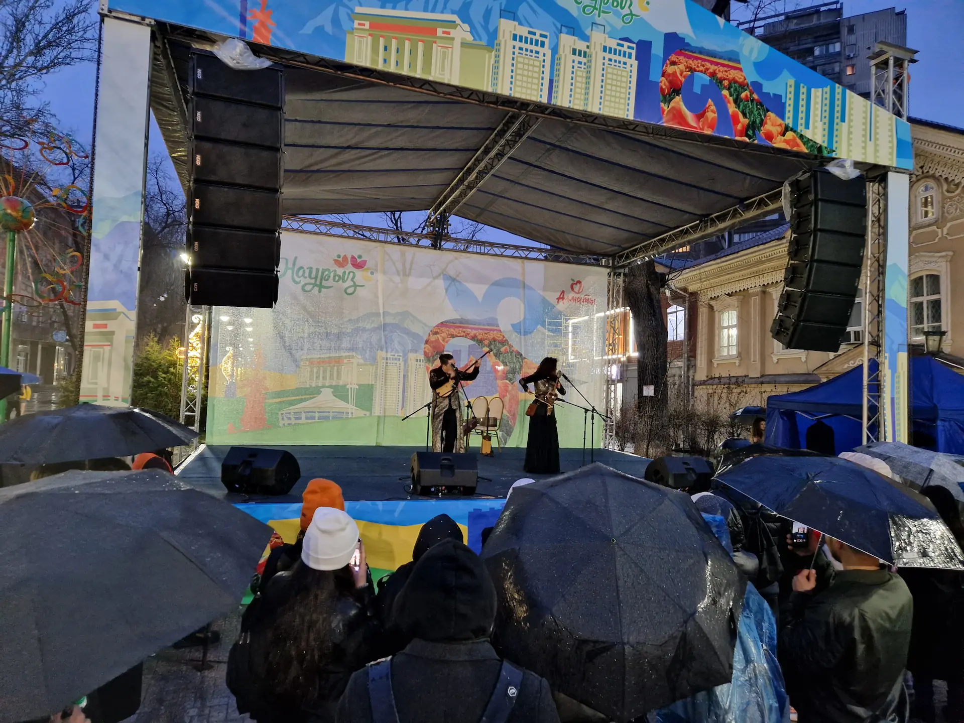 Un petit concert de Nauryz, peu de public sous des parapluies noirs